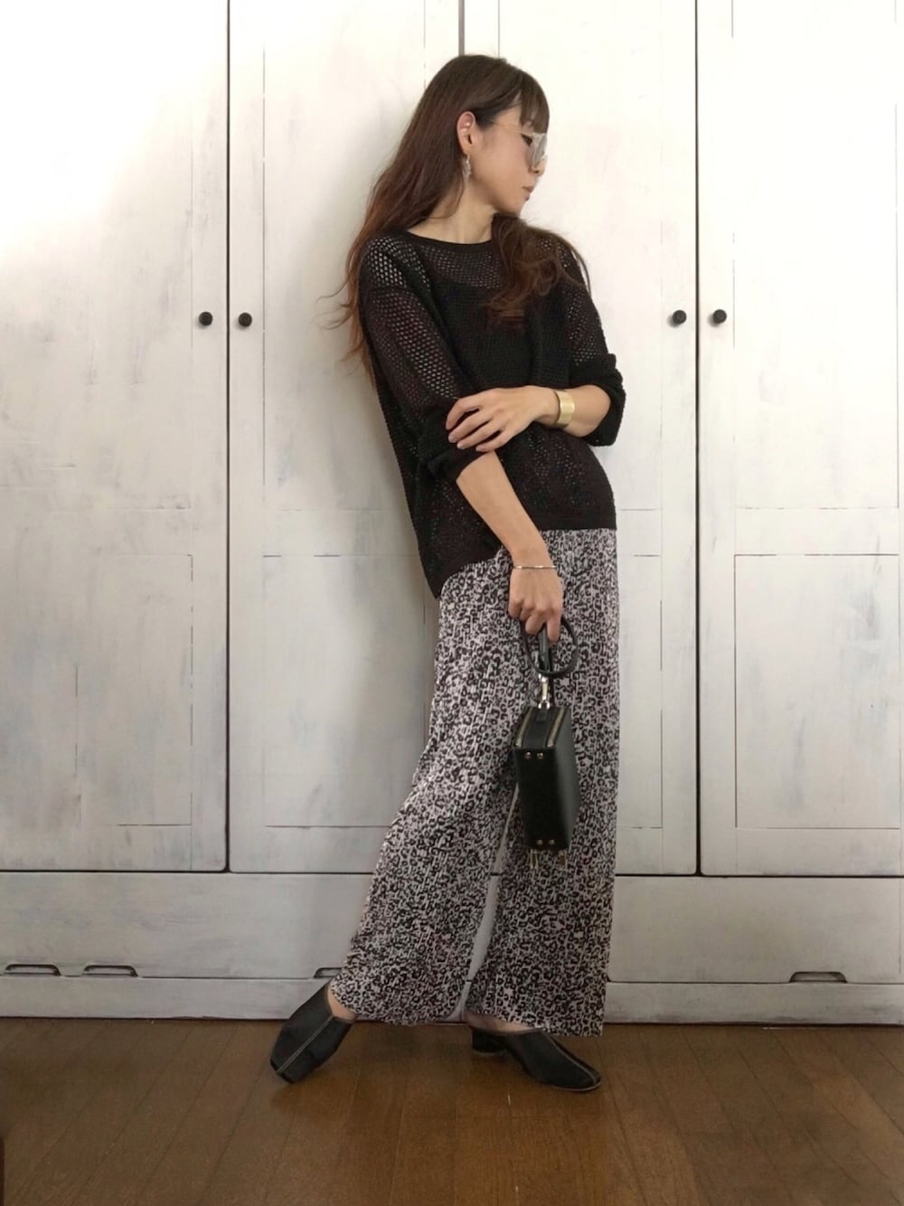 ベージュ系のその他パンツ、ブラック系のニット/セーター、ブラック系のサンダルを着用したレディースの秋コーディネートの1枚目の写真