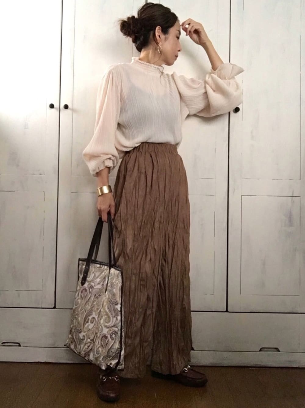 ベージュ系のトップス、ブラウン系のその他パンツ、ホワイト系のトートバッグを着用したレディースの秋コーディネートの1枚目の写真