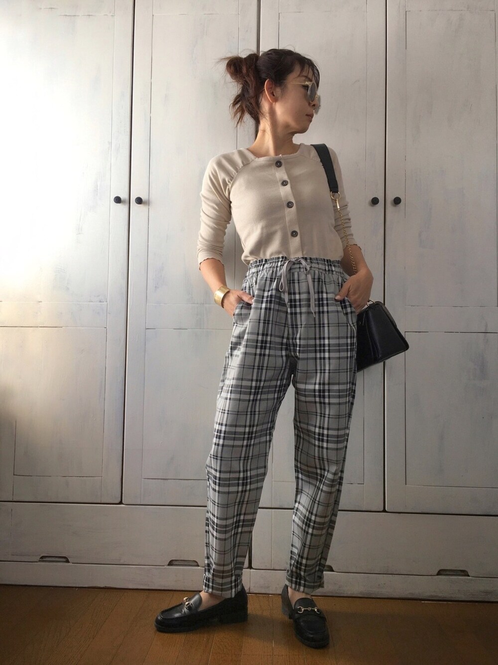 ベージュ系のトップス、グレー系のその他パンツ、ブラック系のバッグを着用したレディースの秋コーディネートの1枚目の写真