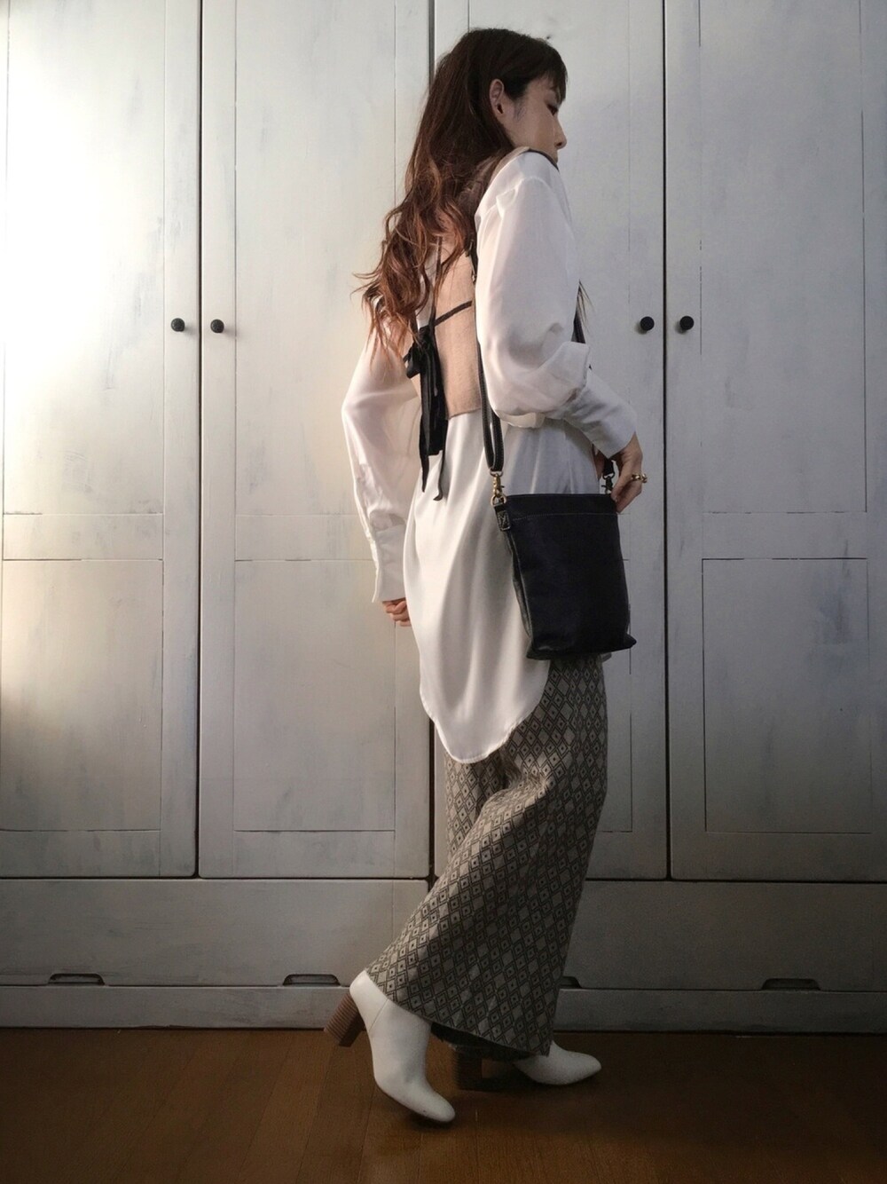 ホワイト系のシャツ/ブラウス、ブラウン系のベスト、ブラック系のショルダーバッグを着用したレディースの秋コーディネートの1枚目の写真
