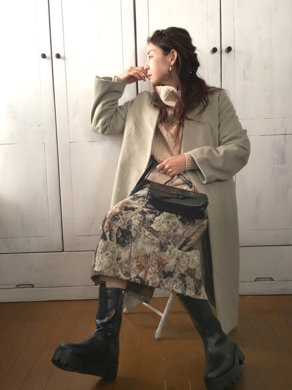 グリーン系のノーカラージャケット、ベージュ系のニット/セーター、ブラック系のスカートを着用したレディースの冬コーディネートの1枚目の写真