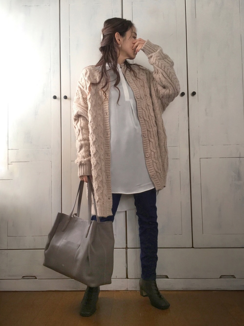ベージュ系のカーディガン/ボレロ、ホワイト系のシャツ/ブラウス、グレー系のトートバッグを着用したレディースの冬コーディネートの1枚目の写真