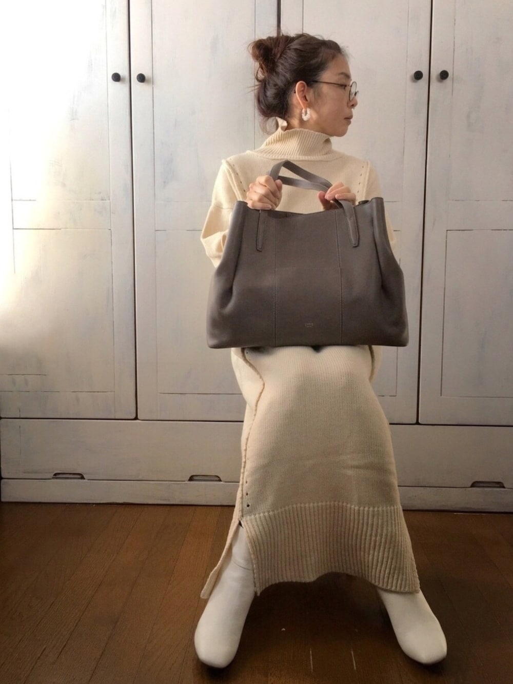 グレー系のトートバッグ、ホワイト系のワンピース、ベージュ系のその他を着用したレディースの冬コーディネートの1枚目の写真
