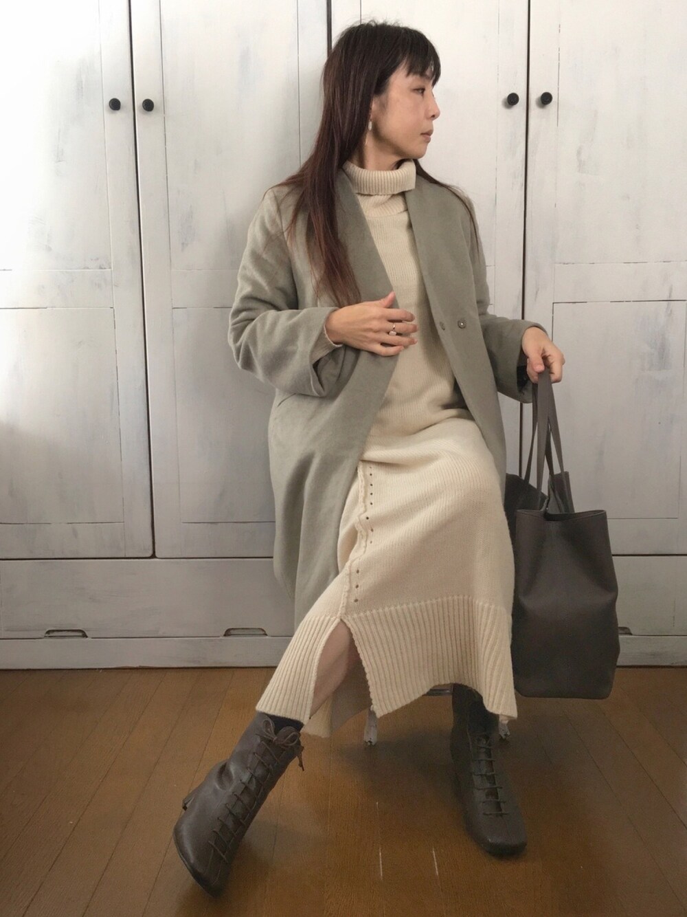 グリーン系のノーカラージャケット、ホワイト系のワンピース、グレー系のトートバッグを着用したレディースの冬コーディネートの1枚目の写真