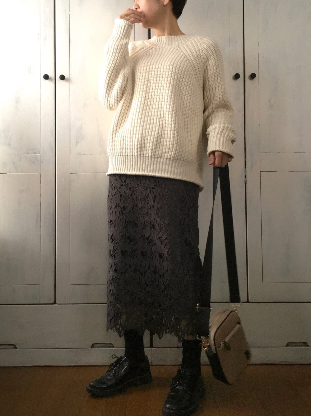 ホワイト系のニット/セーター、その他のスカート、ベージュ系のショルダーバッグを着用したレディースの冬コーディネートの1枚目の写真