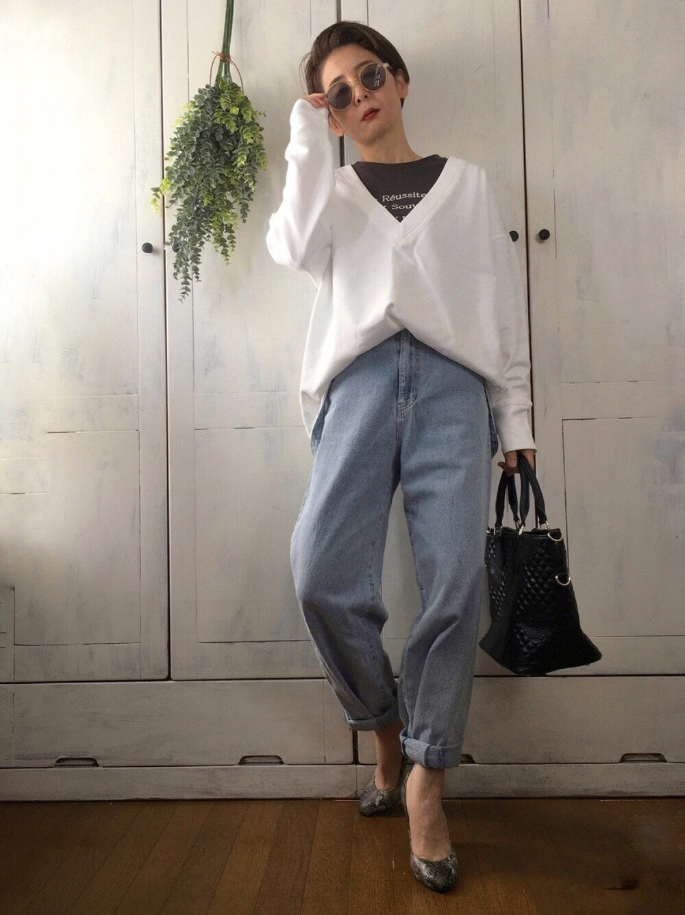 ホワイト系のスウェット、グレー系のTシャツ/カットソー、ブルー系のデニムパンツを着用したレディースの冬コーディネートの1枚目の写真