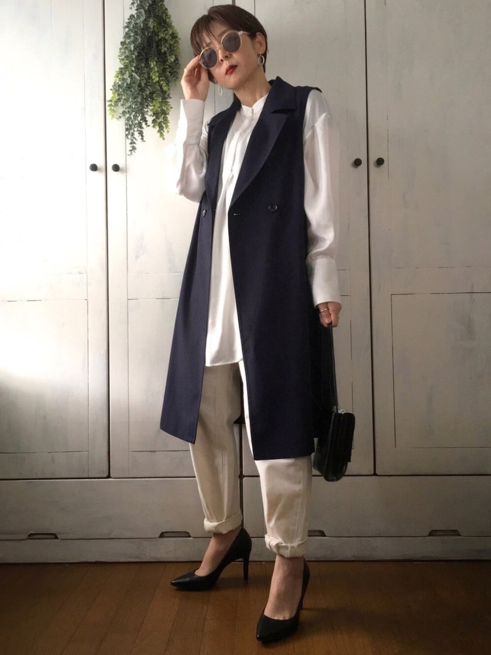 ブルー系のベスト、ホワイト系のシャツ/ブラウス、ホワイト系のデニムパンツを着用したレディースの春コーディネートの1枚目の写真