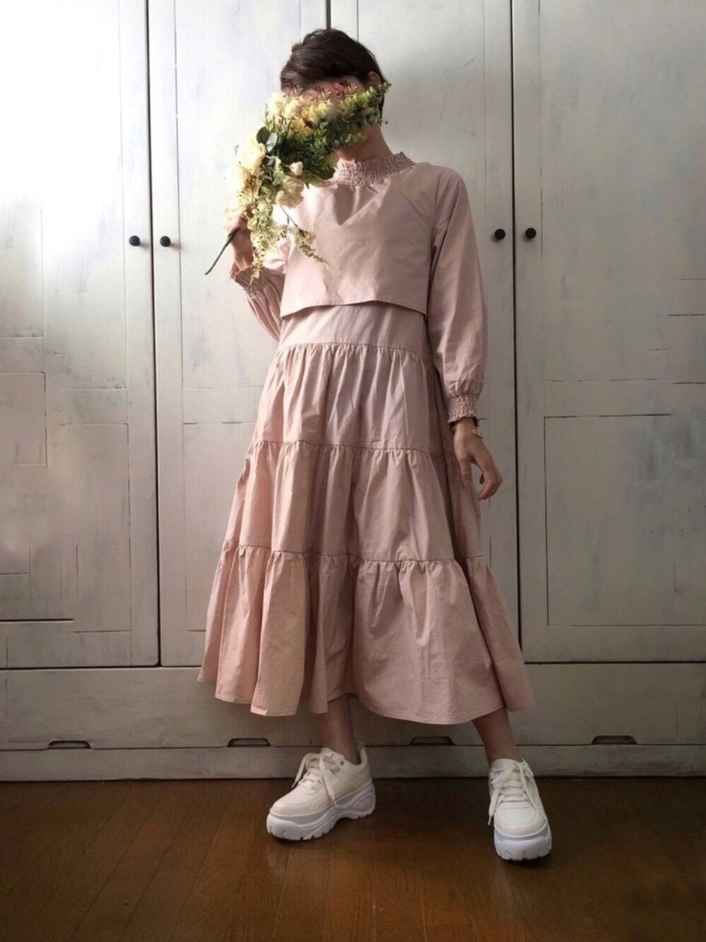 ベージュ系のワンピース、ホワイト系のスニーカー、ベージュ系のワンピース/ドレスを着用したレディースの春コーディネートの1枚目の写真