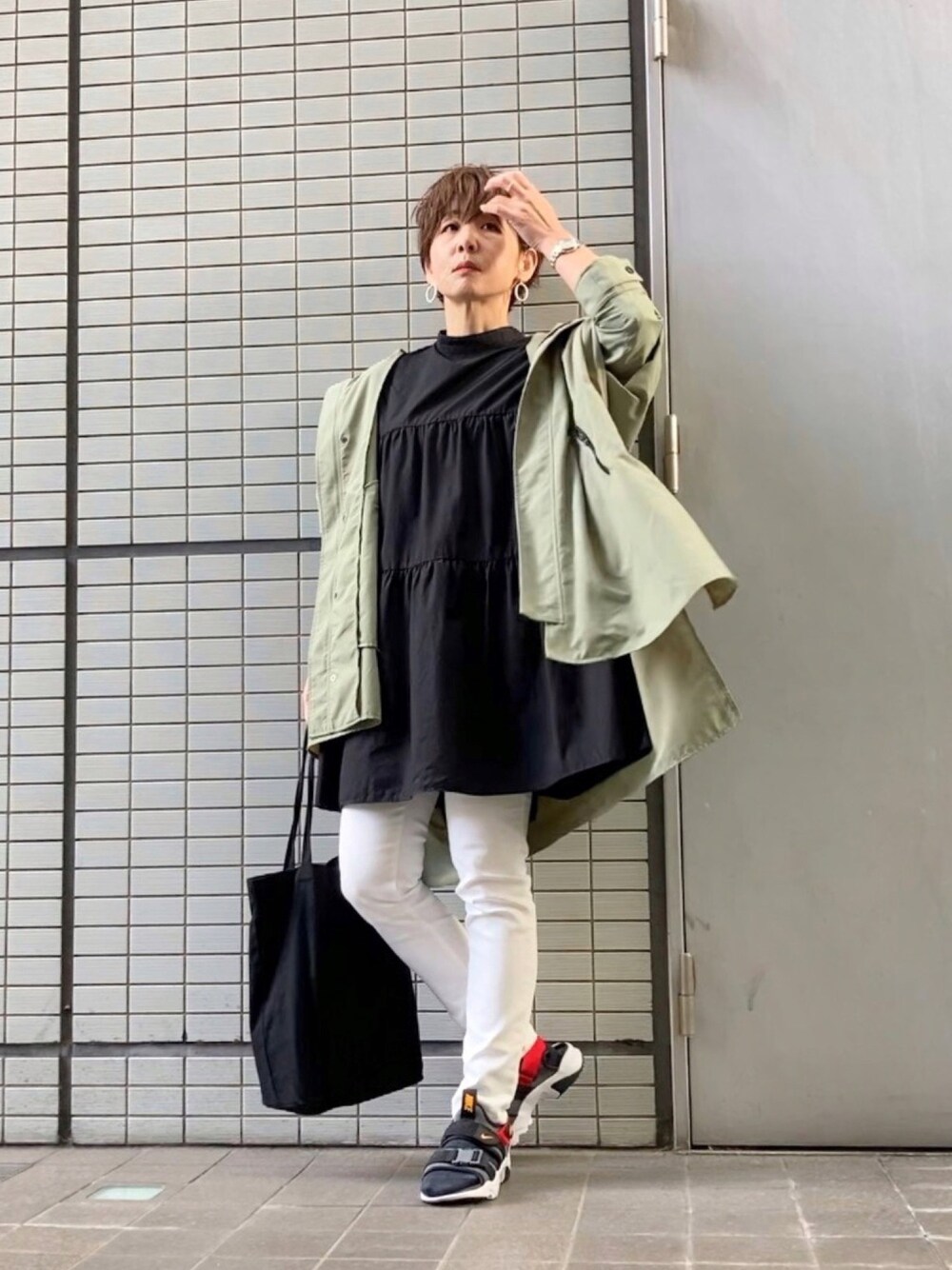 ブラック系のシャツ/ブラウス、ホワイト系のパンツ、ブラック系のトートバッグを着用したレディースの春コーディネートの1枚目の写真
