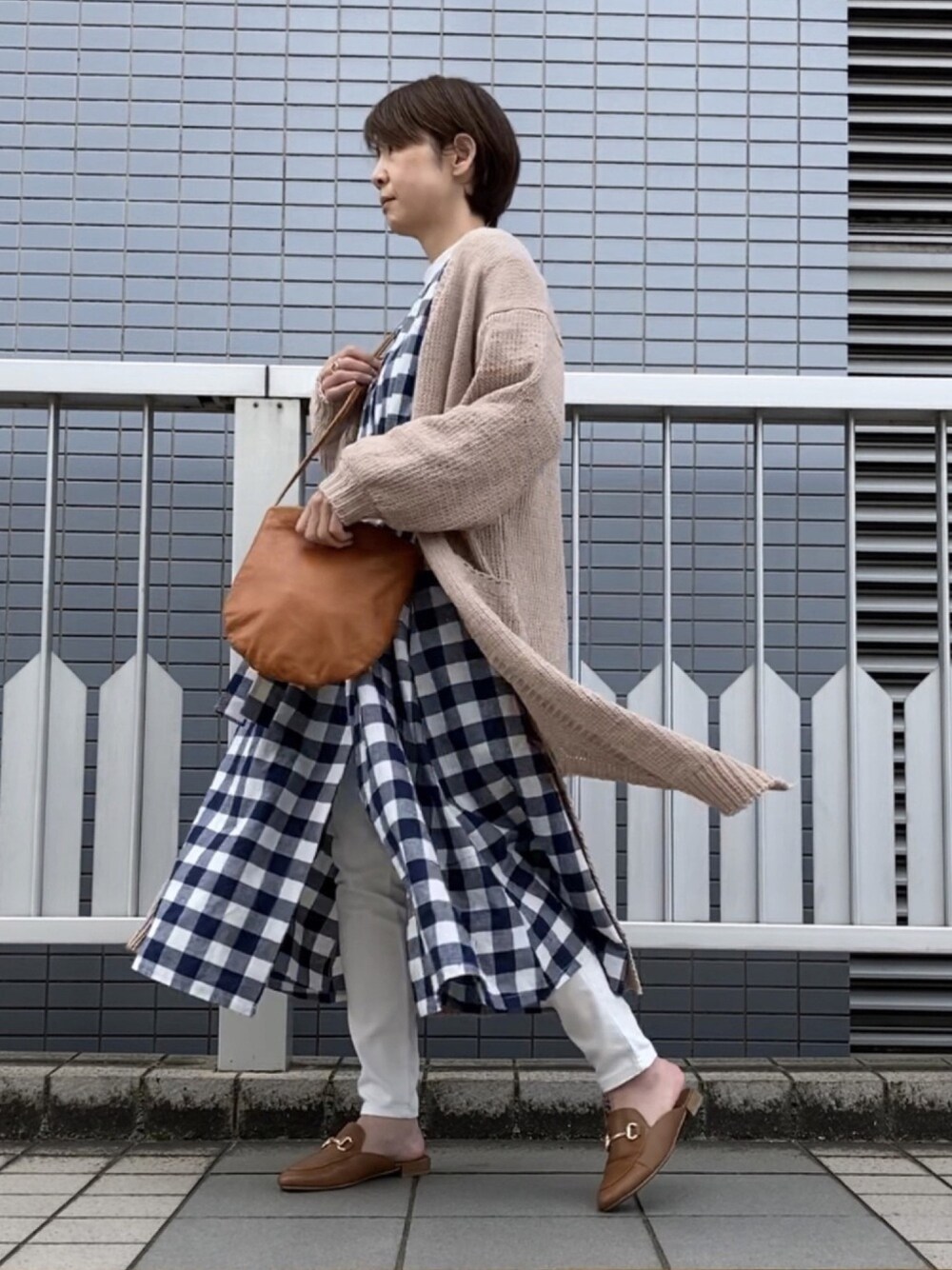 ブルー系のワンピース、ベージュ系のカーディガン/ボレロ、イエロー系のショルダーバッグを着用したレディースの春コーディネートの1枚目の写真