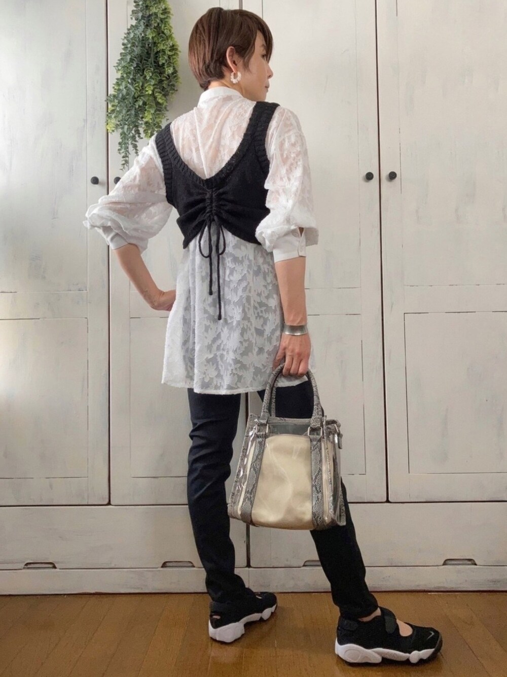 ブラック系のベスト、ホワイト系のシャツ/ブラウス、ブラック系のデニムパンツを着用したレディースの春コーディネートの1枚目の写真