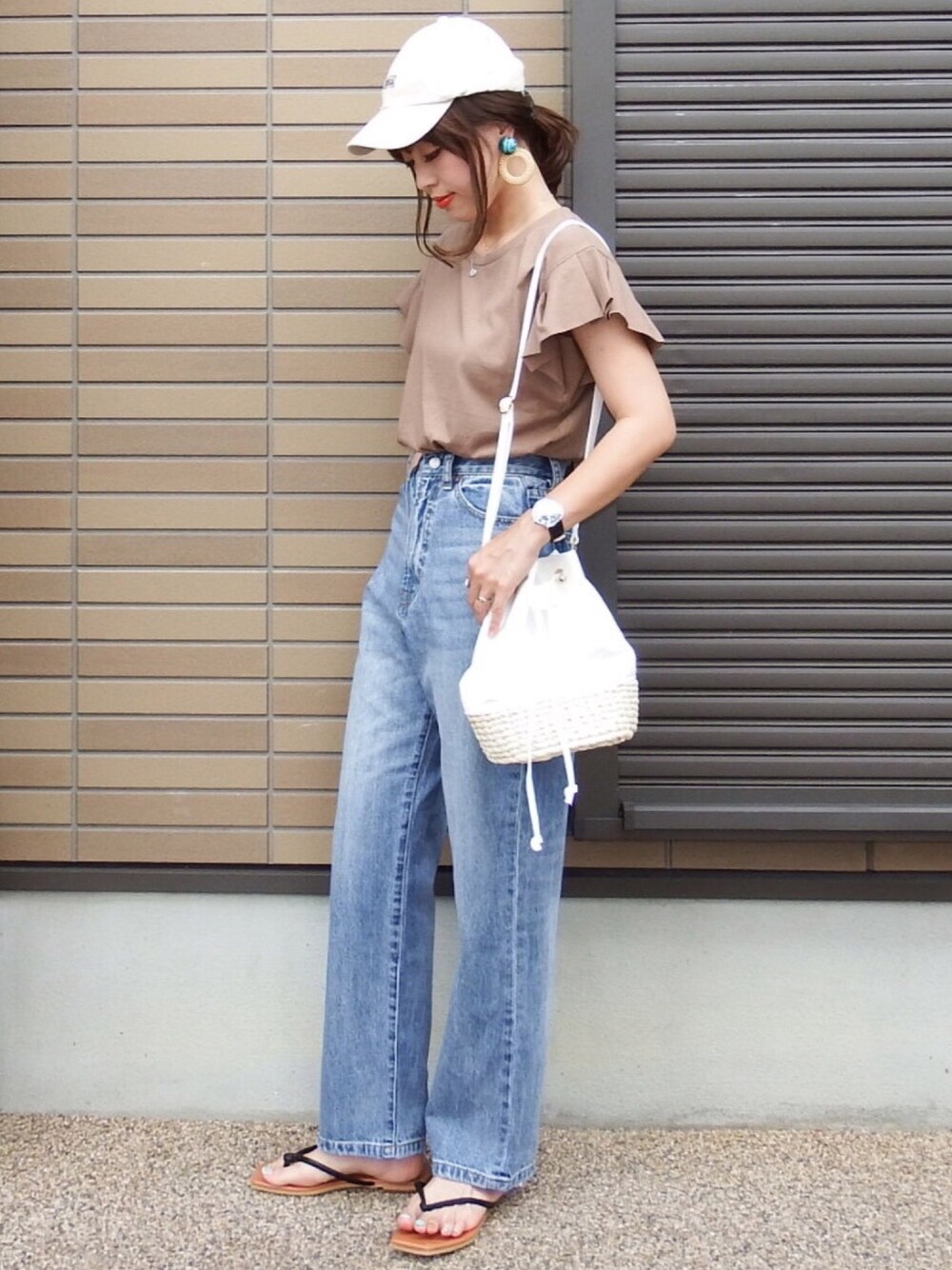 ブラウン系のTシャツ/カットソー、ブルー系のデニムパンツ、ホワイト系のショルダーバッグを着用したレディースの夏コーディネートの1枚目の写真