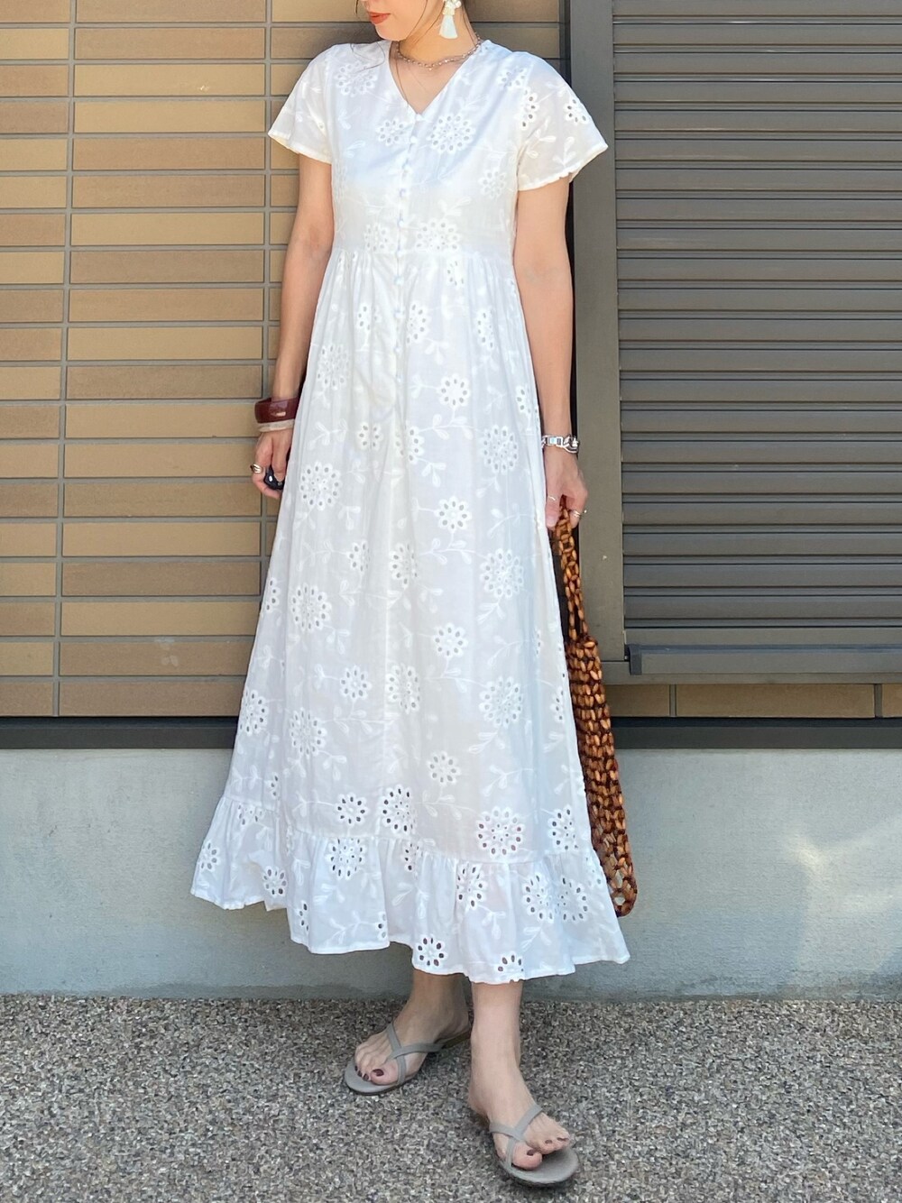 ホワイト系のワンピース、ブラウン系のトートバッグ、ブラウン系のサンダルを着用したレディースの夏コーディネートの1枚目の写真