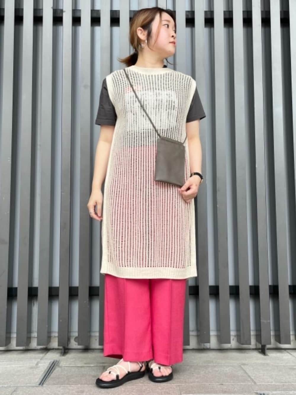 ブラック系のTシャツ/カットソー、レッド系のその他パンツ、ベージュ系のワンピースを着用したレディースの春コーディネートの1枚目の写真