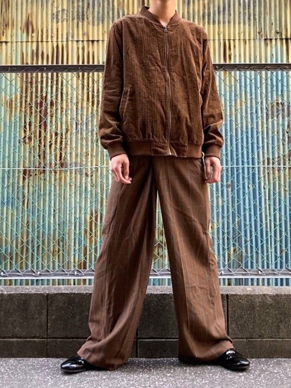 ブラウン系のジャケット/アウター、ブラウン系のパンツ、ブラック系のスリッポンを着用したメンズの冬コーディネートの1枚目の写真