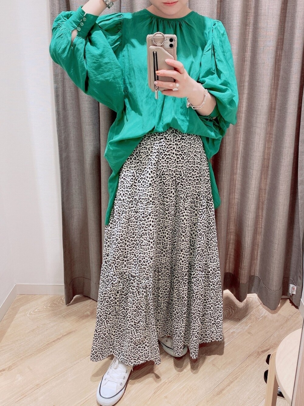 ホワイト系のスカート、ホワイト系のスニーカー、グリーン系のシャツ/ブラウスを着用したレディースの春コーディネートの1枚目の写真