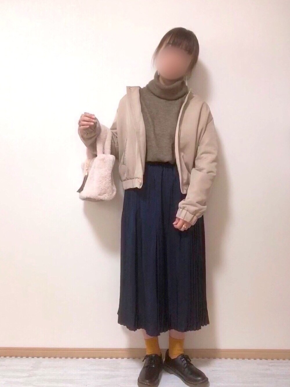 ブラウン系のニット/セーター、ベージュ系のノーカラージャケット、ブルー系のスカートを着用したレディースの秋コーディネートの1枚目の写真