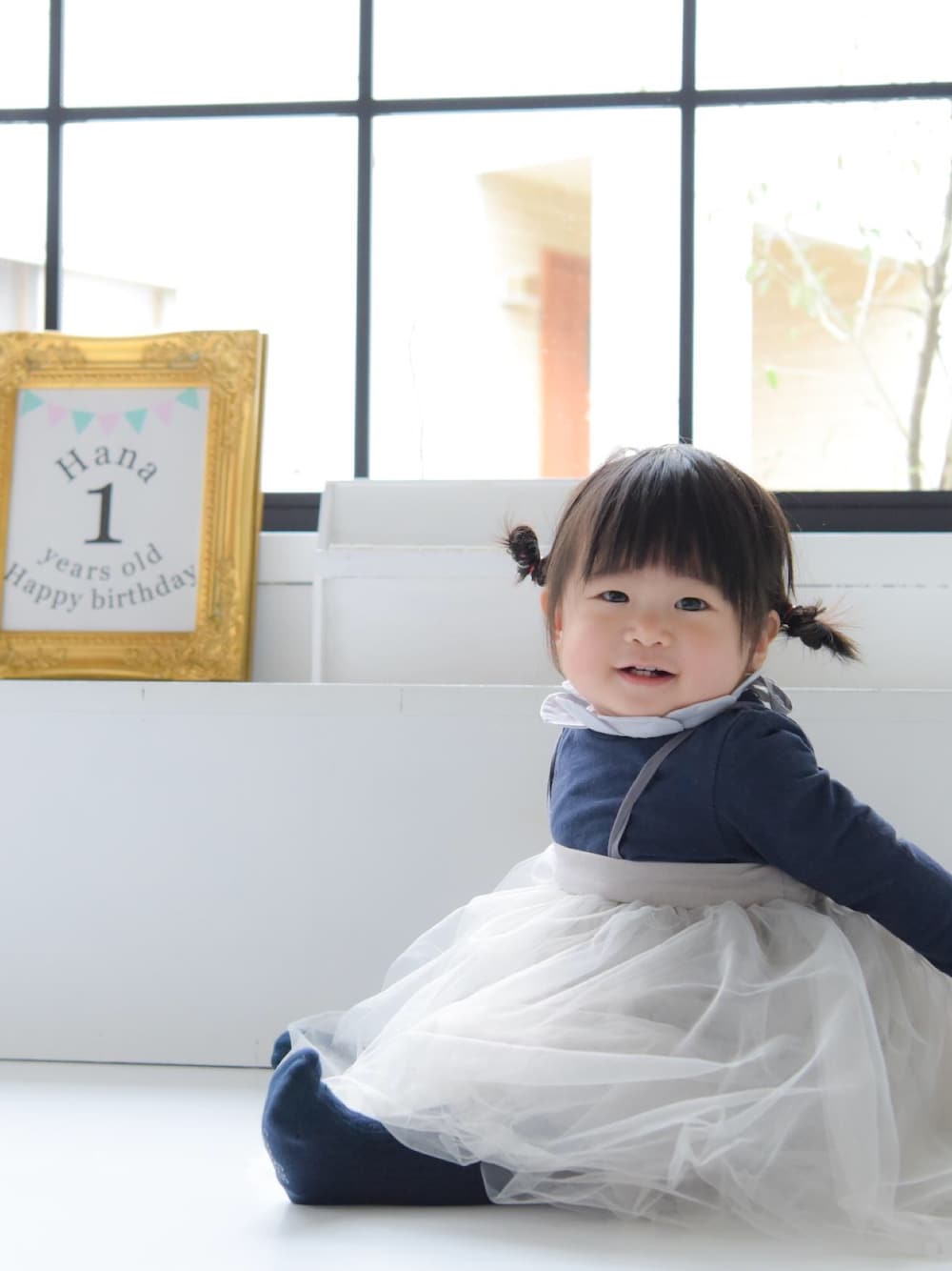 グレー系のスカート、ブルー系のロンパース、ブルー系のタイツ/ストッキングを着用したキッズの春コーディネートの1枚目の写真