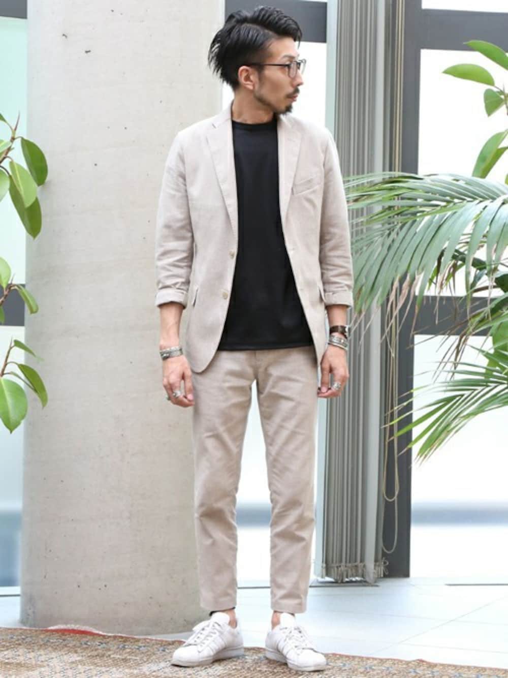 ベージュ系のテーラードジャケット、ベージュ系のスラックス、ブラック系のTシャツ/カットソーを着用したメンズの春コーディネートの1枚目の写真