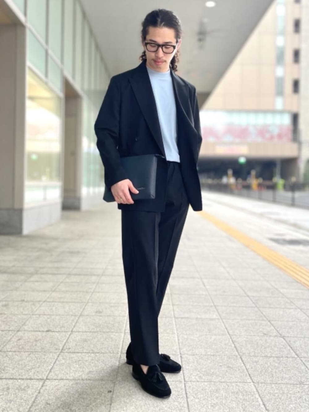 ブルー系のショルダーバッグ、ブラック系のローファー、ブラック系のテーラードジャケットを着用したメンズの春コーディネートの1枚目の写真