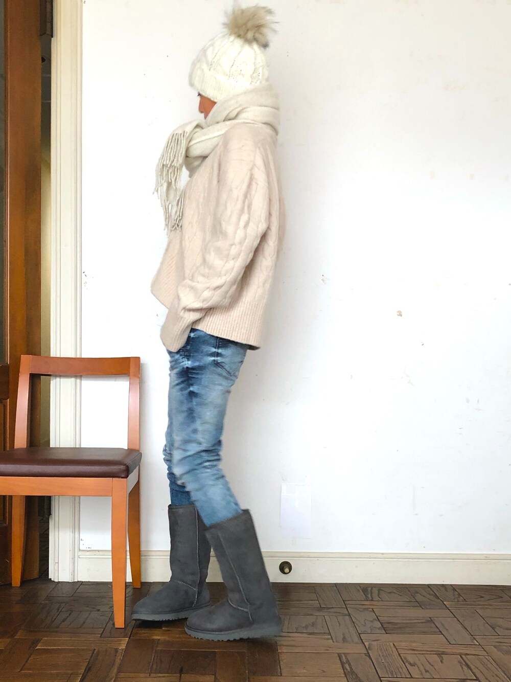 ベージュ系のカーディガン/ボレロ、ブルー系のデニムパンツ、グレー系のブーツを着用したレディースの冬コーディネートの1枚目の写真