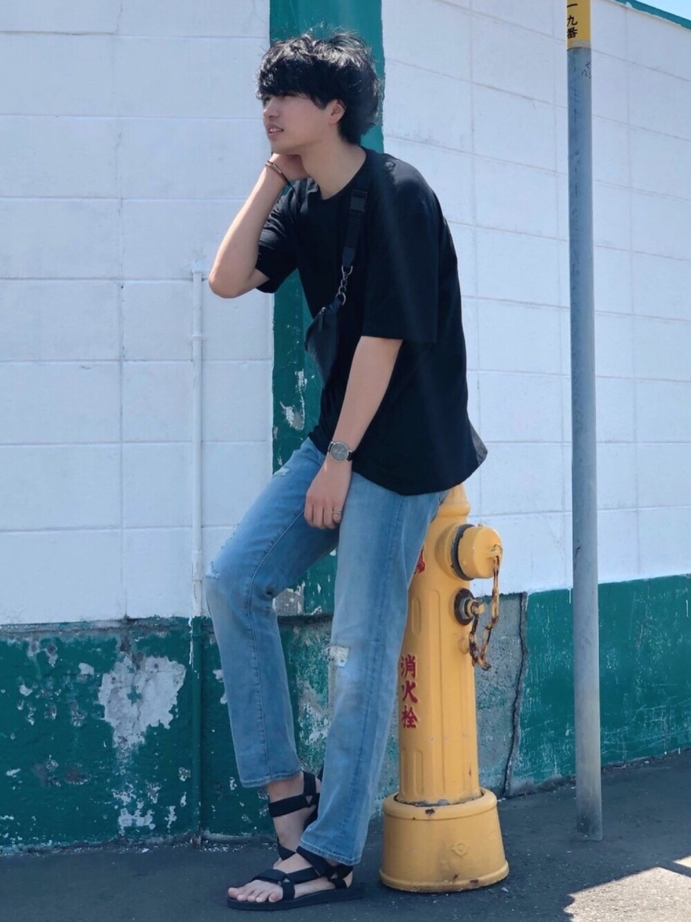 ブラック系のボディバッグ/ウエストポーチ、ブラック系のTシャツ/カットソー、ブルー系のデニムパンツを着用したメンズの夏コーディネートの1枚目の写真