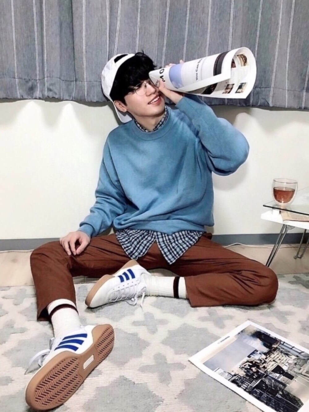 ホワイト系のスニーカー、ブラウン系のパンツ、ホワイト系のキャップを着用したメンズの春コーディネートの1枚目の写真