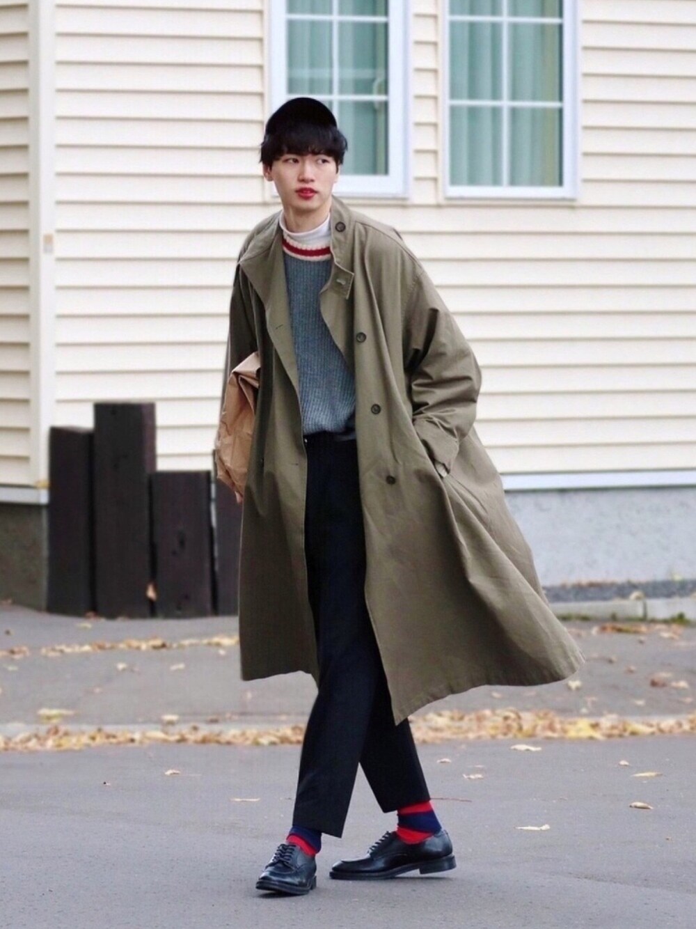 グレー系のニット/セーター、グリーン系のトレンチコート、ブラック系のその他パンツを着用したメンズの秋コーディネートの1枚目の写真