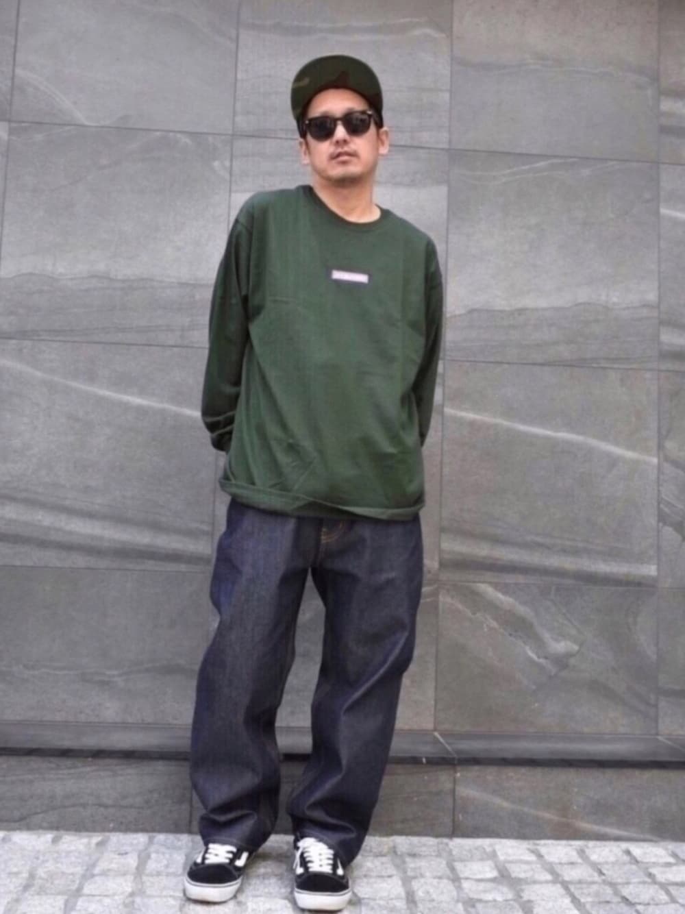 ブラック系のスニーカー、ブルー系のデニムパンツ、ベージュ系のTシャツ/カットソーを着用したメンズの春コーディネートの1枚目の写真