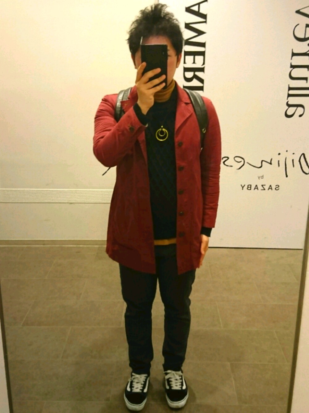 レッド系のステンカラーコート、ベージュ系のTシャツ/カットソー、ブルー系のニット/セーターを着用したメンズの冬コーディネートの1枚目の写真
