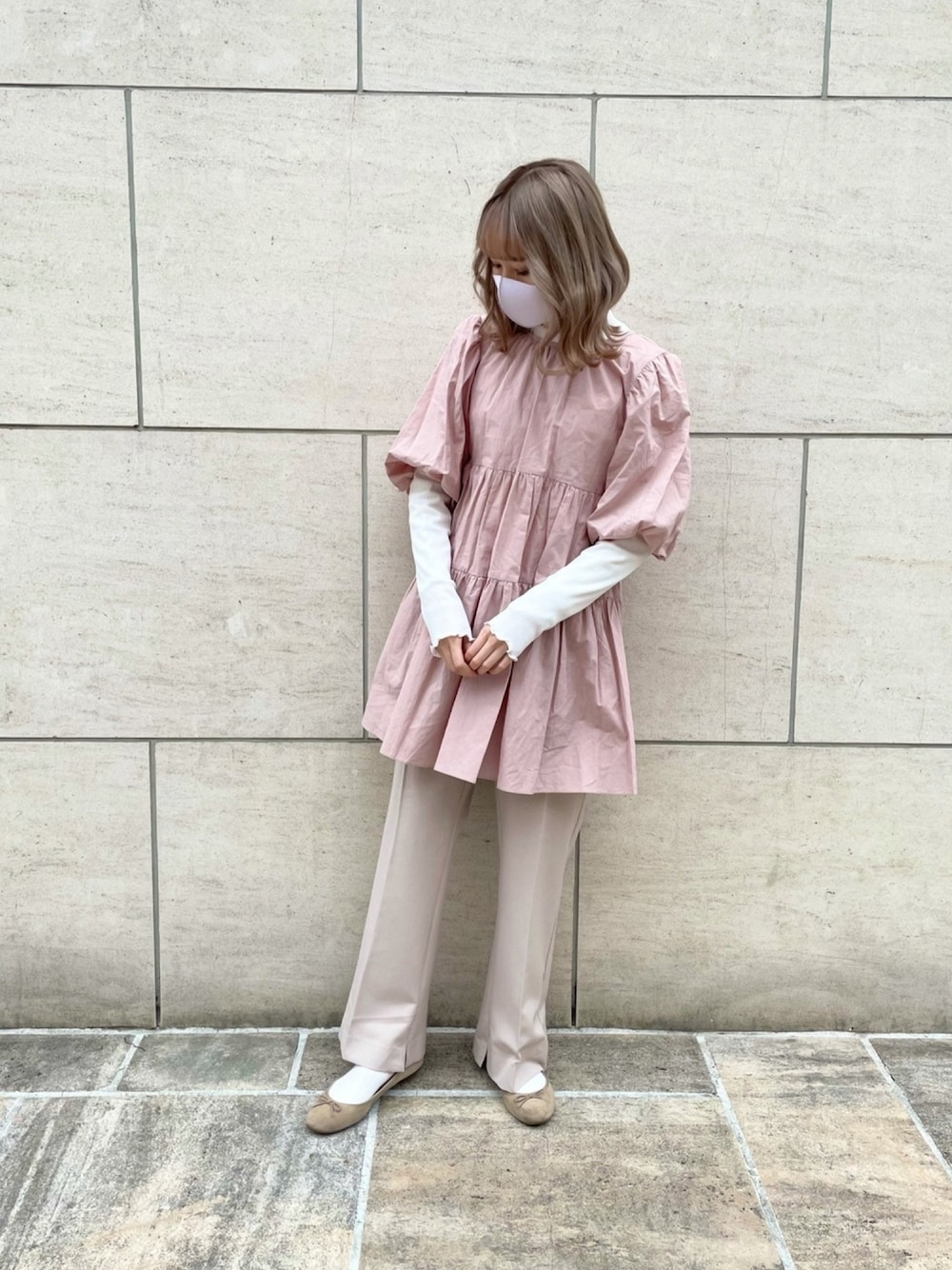 ピンク系のチュニック、ホワイト系のその他パンツを着用したレディースの冬コーディネートの1枚目の写真