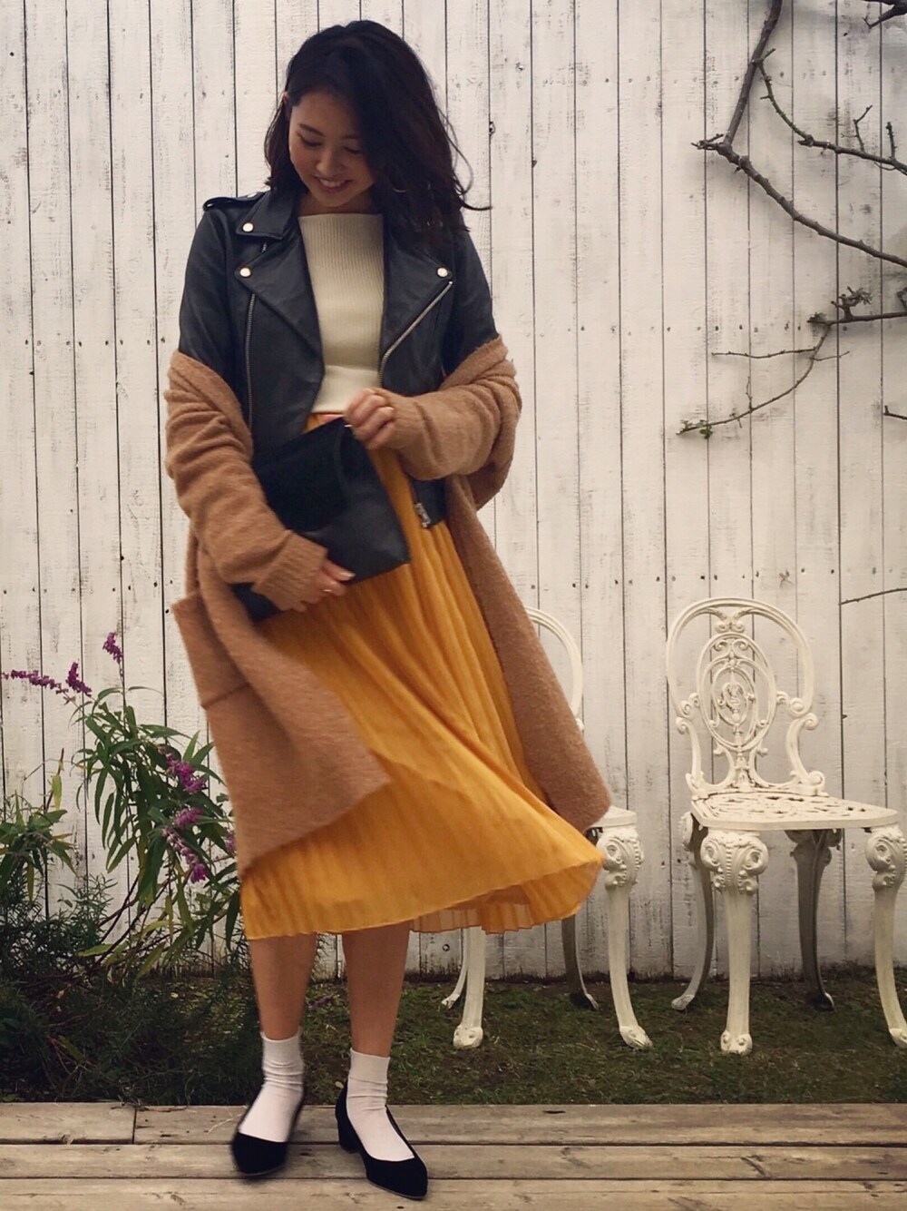 ホワイト系のニット/セーター、ベージュ系のカーディガン/ボレロ、ブラック系のライダースジャケットを着用したレディースの冬コーディネートの1枚目の写真