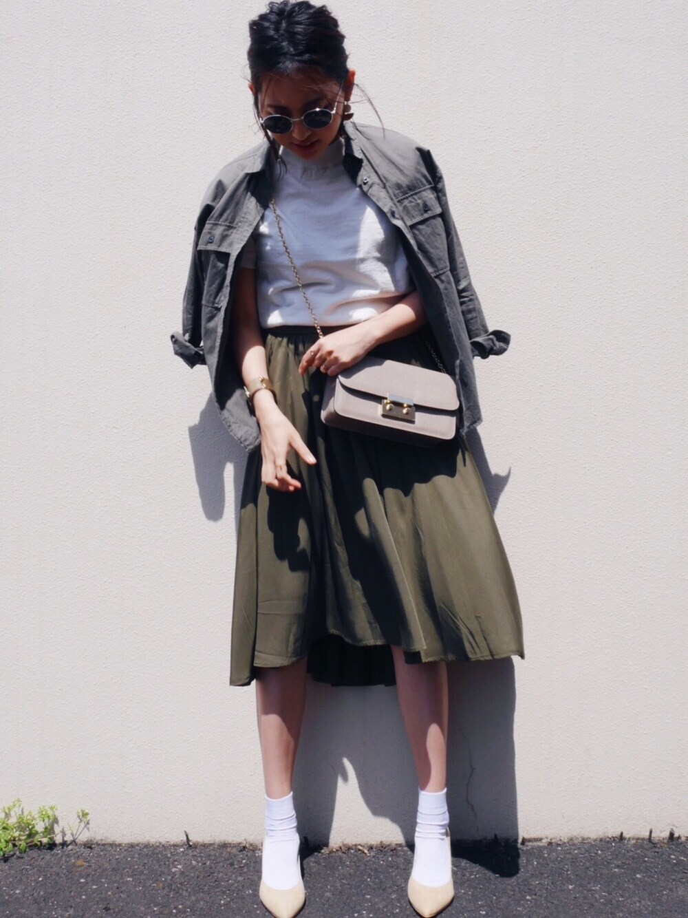 ホワイト系のニット/セーター、ベージュ系のパンプス、ベージュ系のピアス(両耳用)を着用したレディースの春コーディネートの1枚目の写真