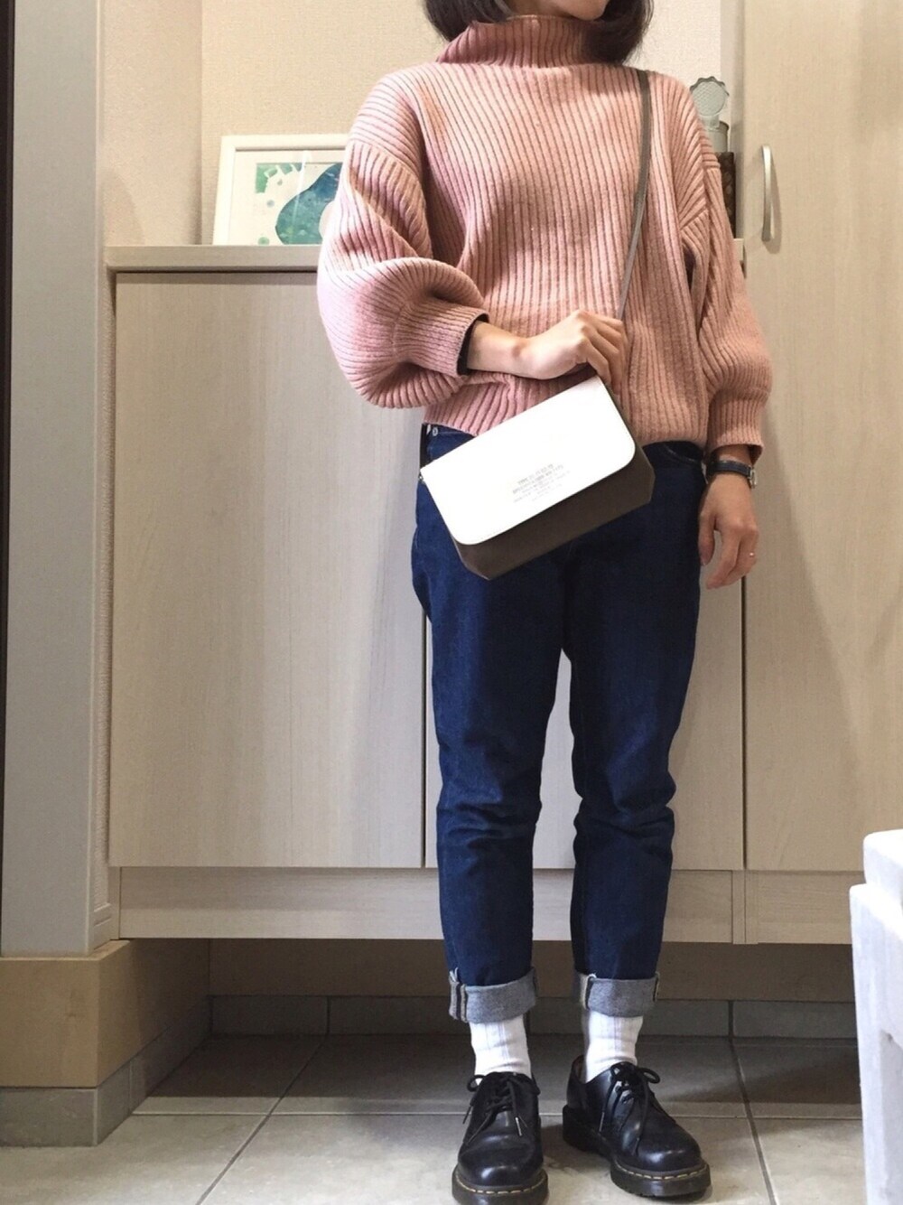 ピンク系のニット/セーター、ブルー系のデニムパンツ、ブラック系のその他シューズを着用したレディースの春コーディネートの1枚目の写真