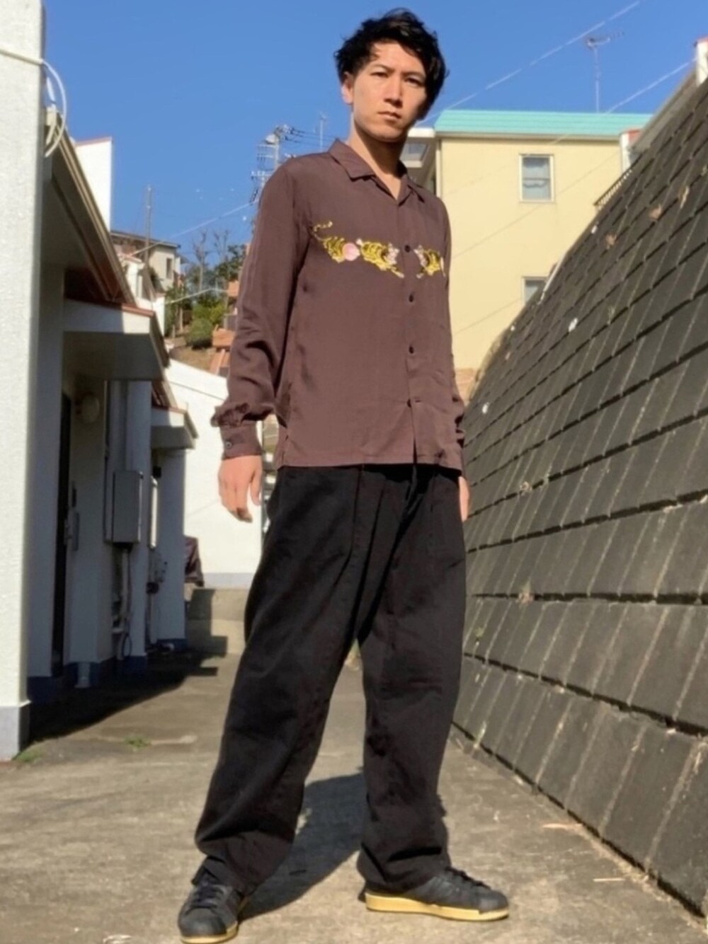 ブラウン系のシャツ/ブラウス、ブラック系のデニムパンツ、ブラック系のスニーカーを着用したメンズの春コーディネートの1枚目の写真