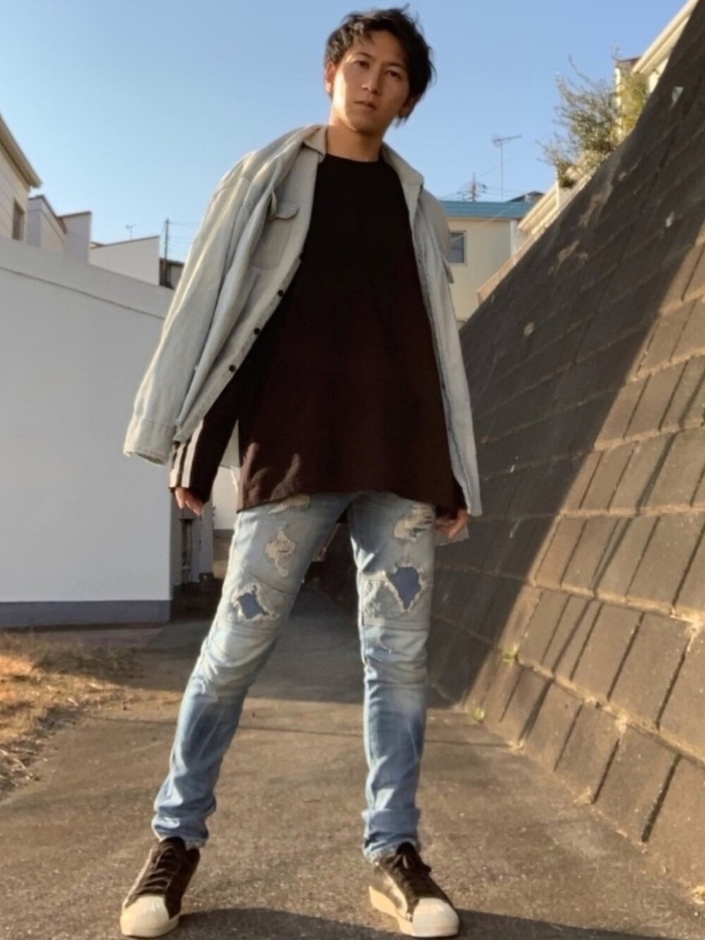 ブルー系のシャツ/ブラウス、ブラック系のTシャツ/カットソー、ブルー系のデニムパンツを着用したメンズの冬コーディネートの1枚目の写真