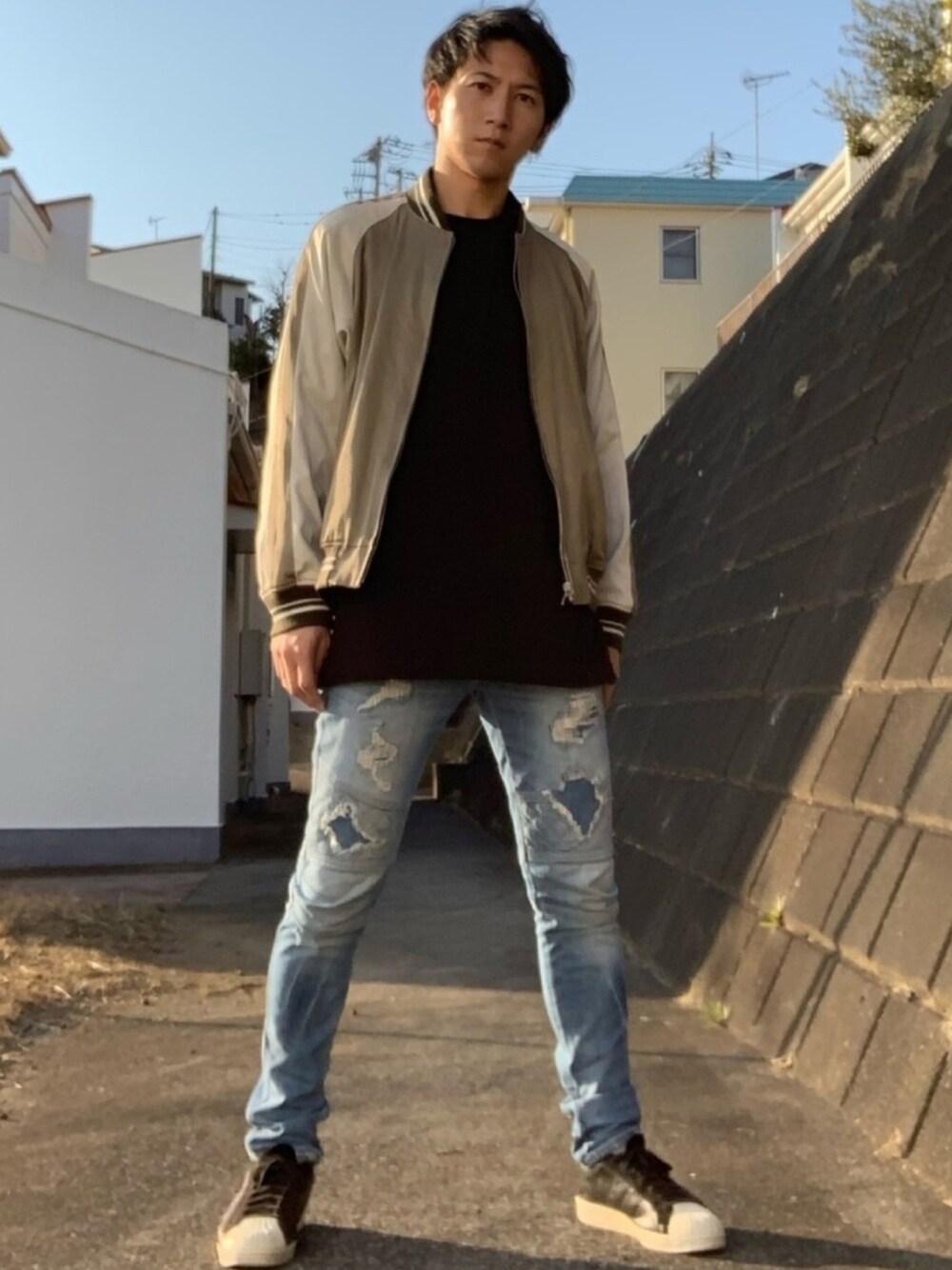 ベージュ系のスカジャン、ブラック系のTシャツ/カットソー、ブルー系のデニムパンツを着用したメンズの春コーディネートの1枚目の写真