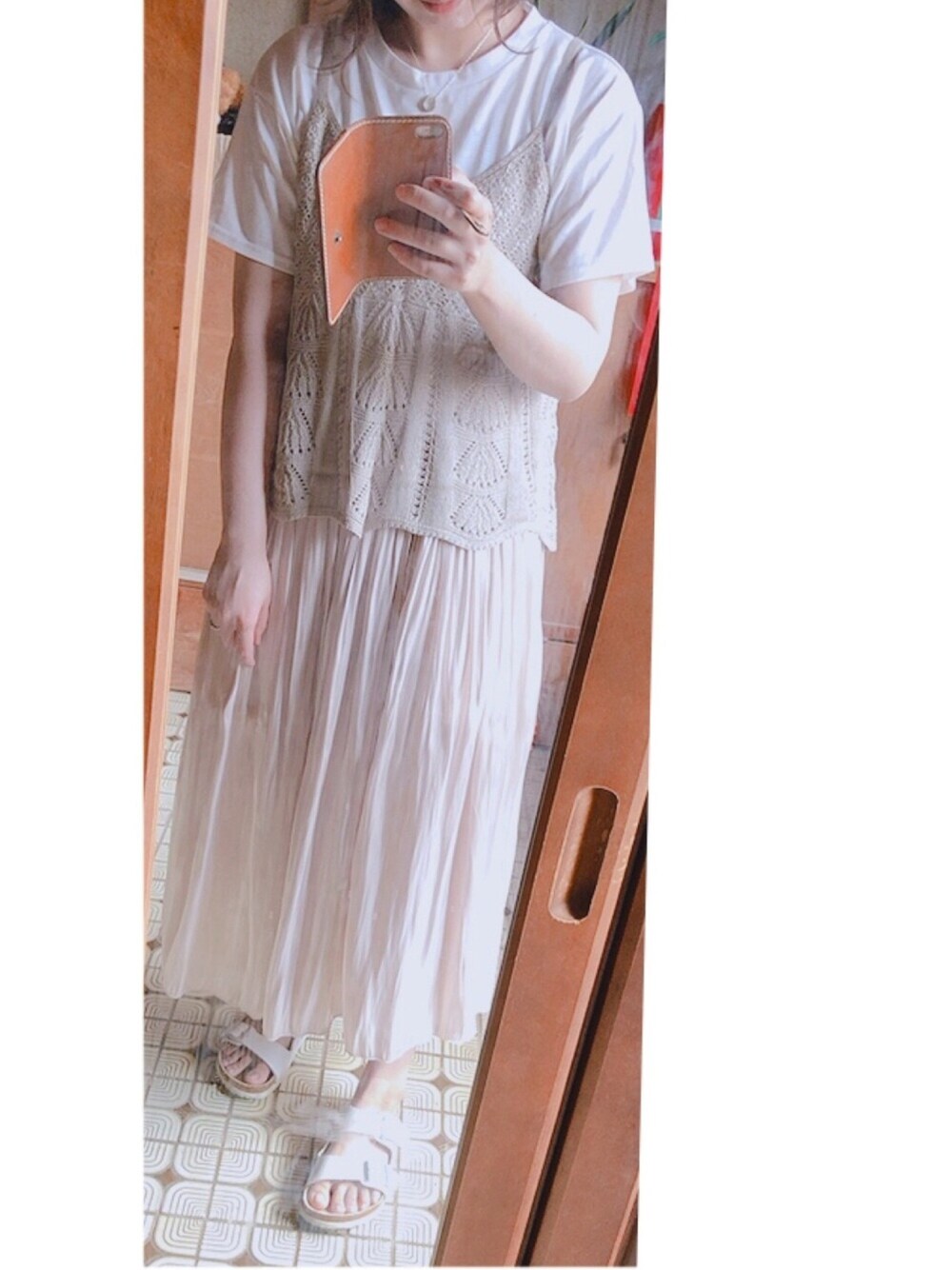 ベージュ系のキャミソール、ピンク系のスカート、ホワイト系のサンダルを着用したレディースの春コーディネートの1枚目の写真