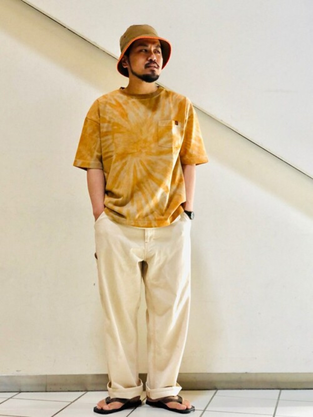 ブラウン系のTシャツ/カットソー、ベージュ系のデニムパンツ、ブラック系のサンダルを着用したメンズの春コーディネートの1枚目の写真