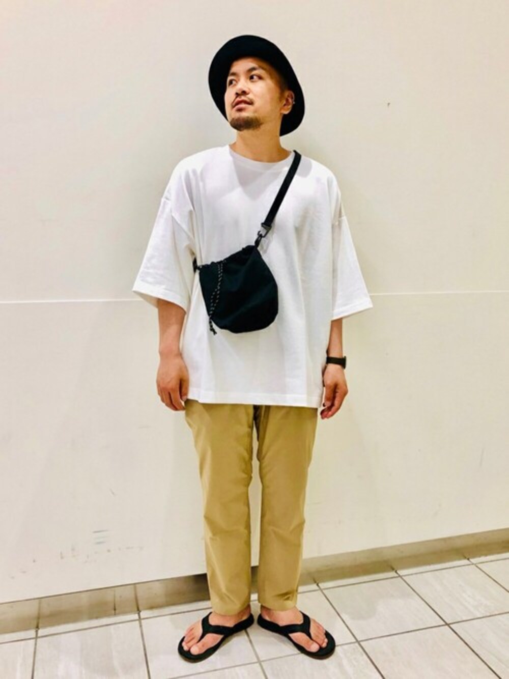 ホワイト系のTシャツ/カットソー、ベージュ系のその他パンツ、ブラック系のサンダルを着用したメンズの春コーディネートの1枚目の写真
