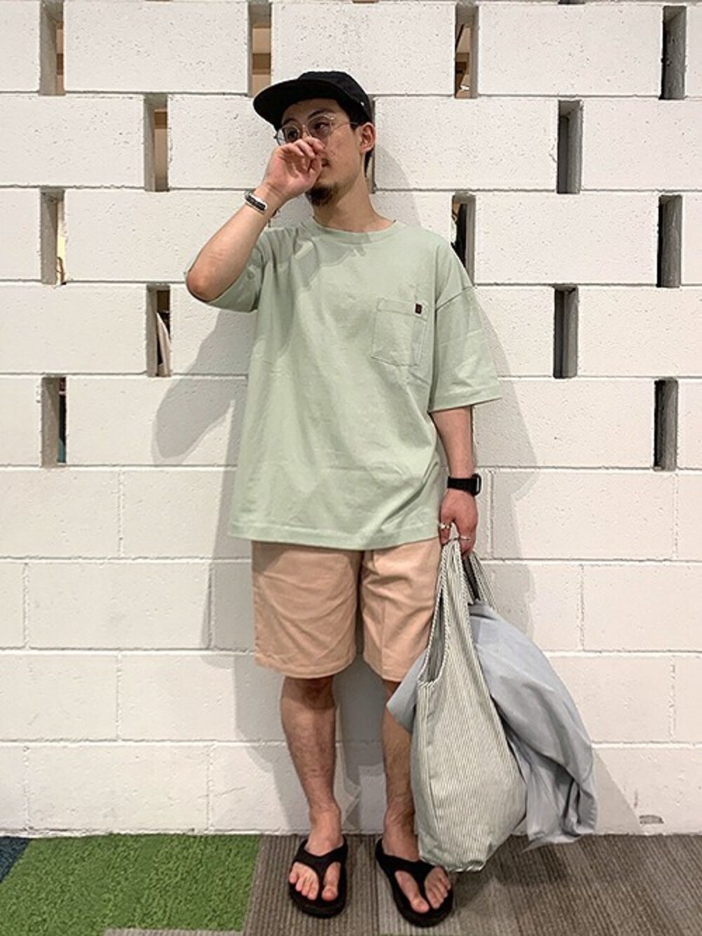 グリーン系のTシャツ/カットソー、ピンク系のその他パンツ、ブルー系のエコバッグ/サブバッグを着用したメンズの夏コーディネートの1枚目の写真