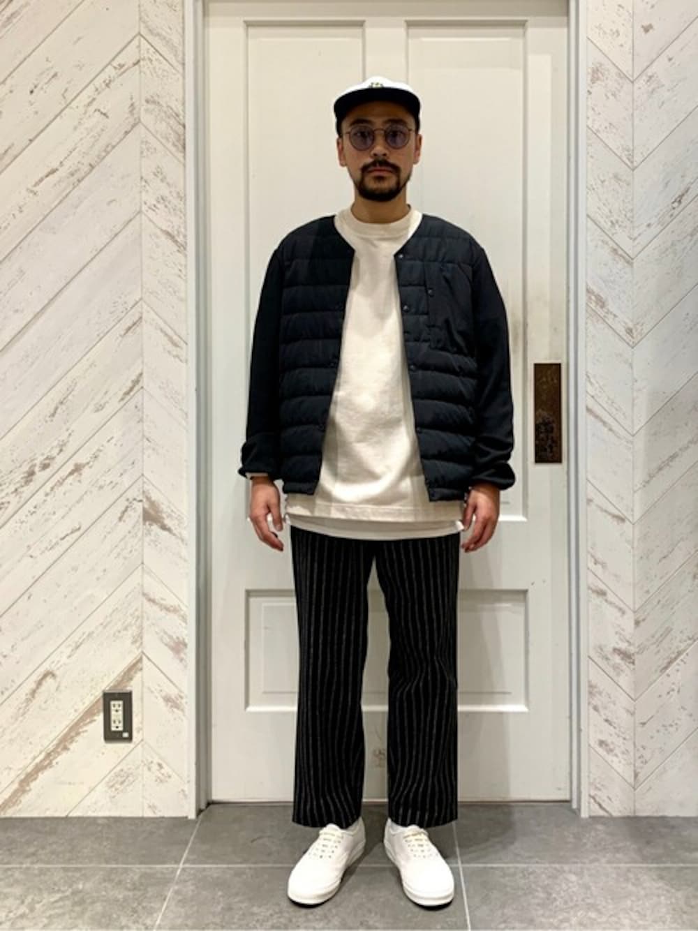 ブラック系のブルゾン、ベージュ系のTシャツ/カットソー、ホワイト系のTシャツ/カットソーを着用したメンズの秋コーディネートの1枚目の写真