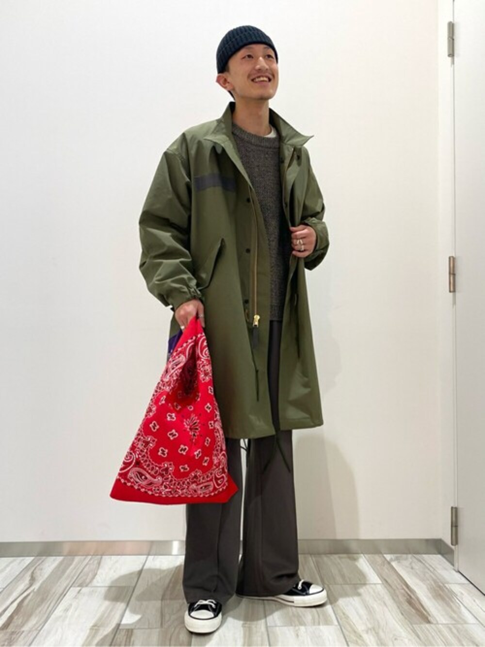 グリーン系のモッズコート、ブラウン系のニット/セーター、グリーン系のスラックスを着用したメンズの冬コーディネートの1枚目の写真