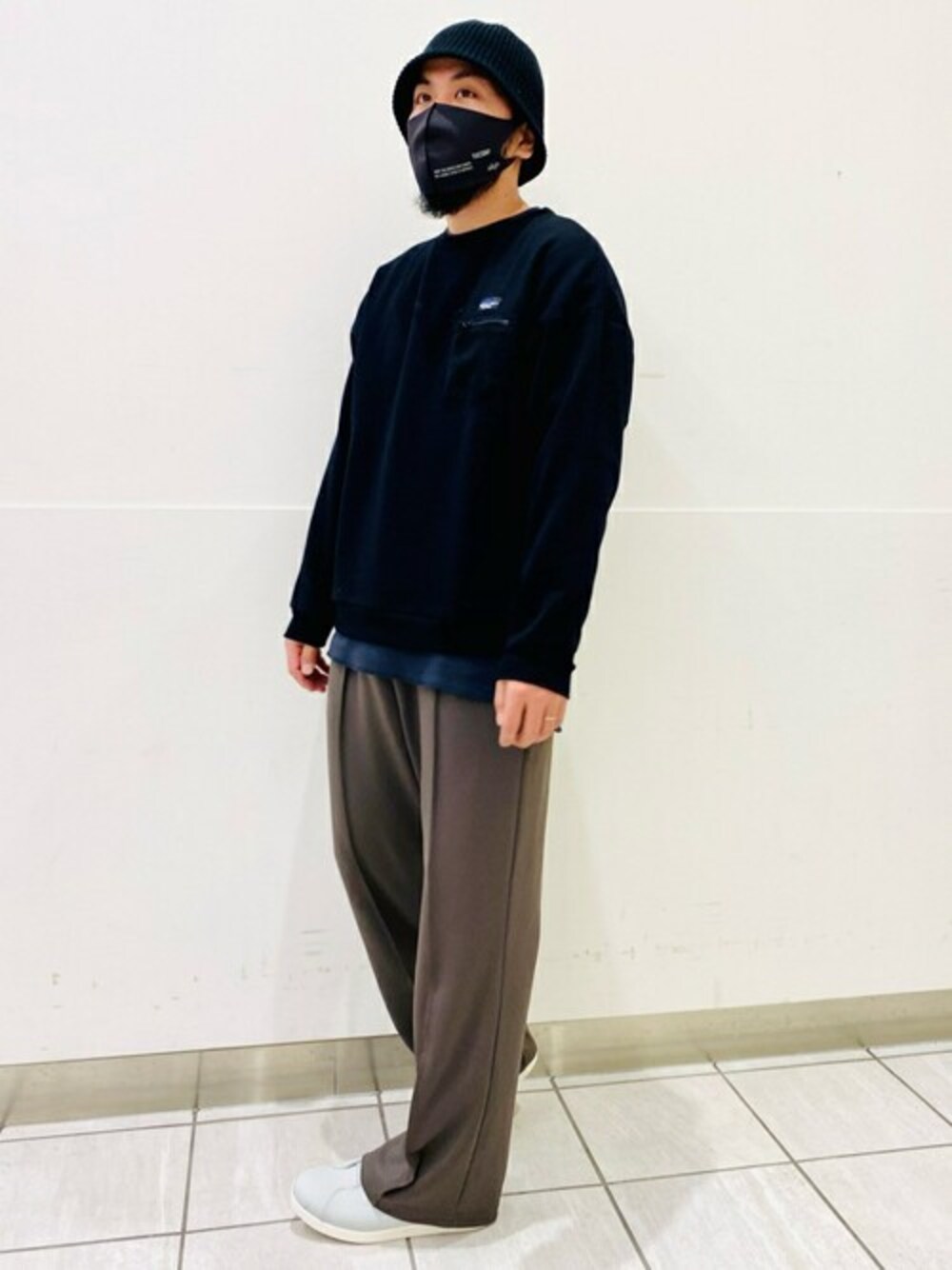 ブラック系のスウェット、ブラック系のTシャツ/カットソー、グリーン系のスラックスを着用したメンズの冬コーディネートの1枚目の写真