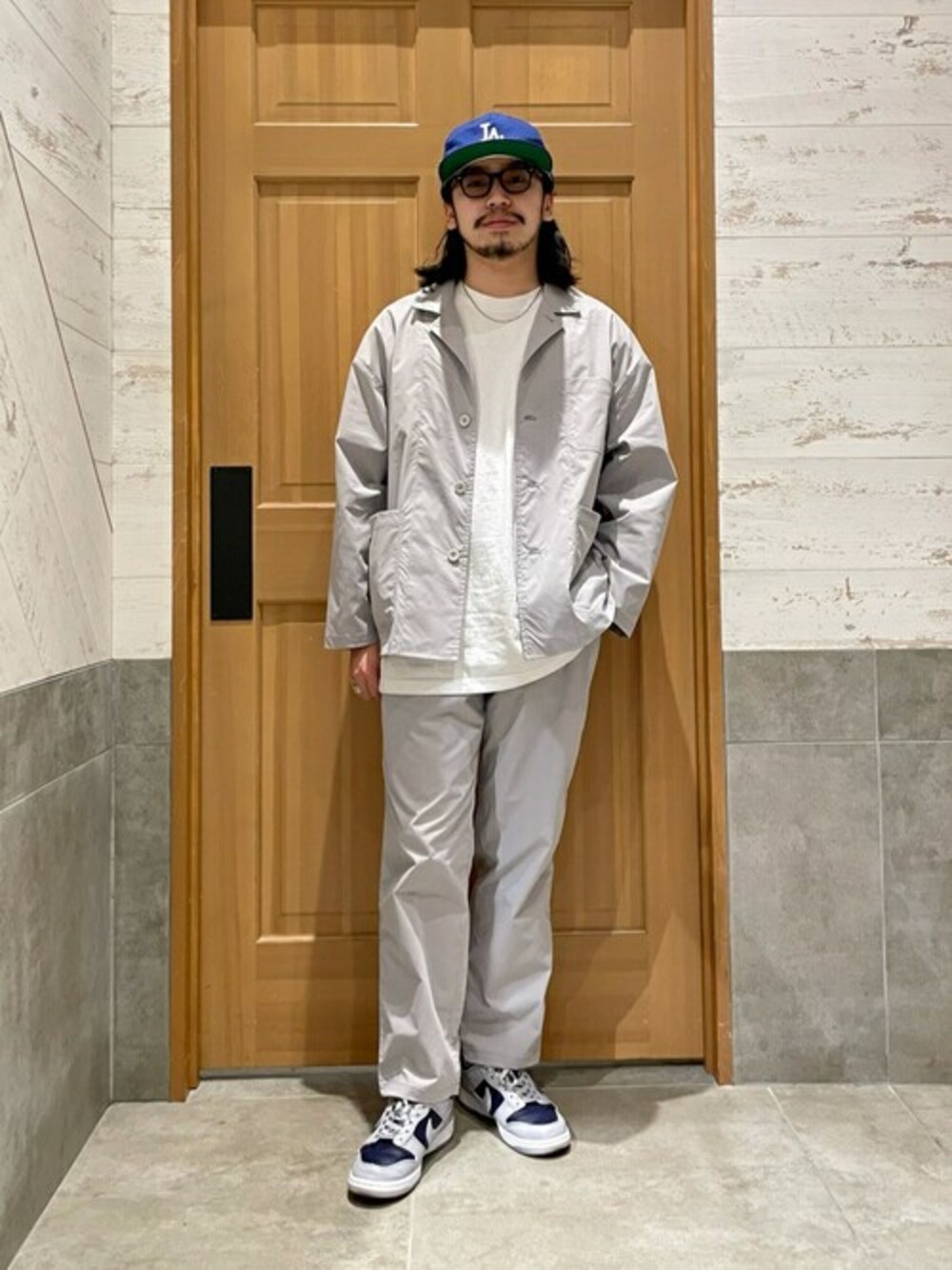 グレー系のセットアップ、ホワイト系のTシャツ/カットソーを着用したメンズの春コーディネートの1枚目の写真