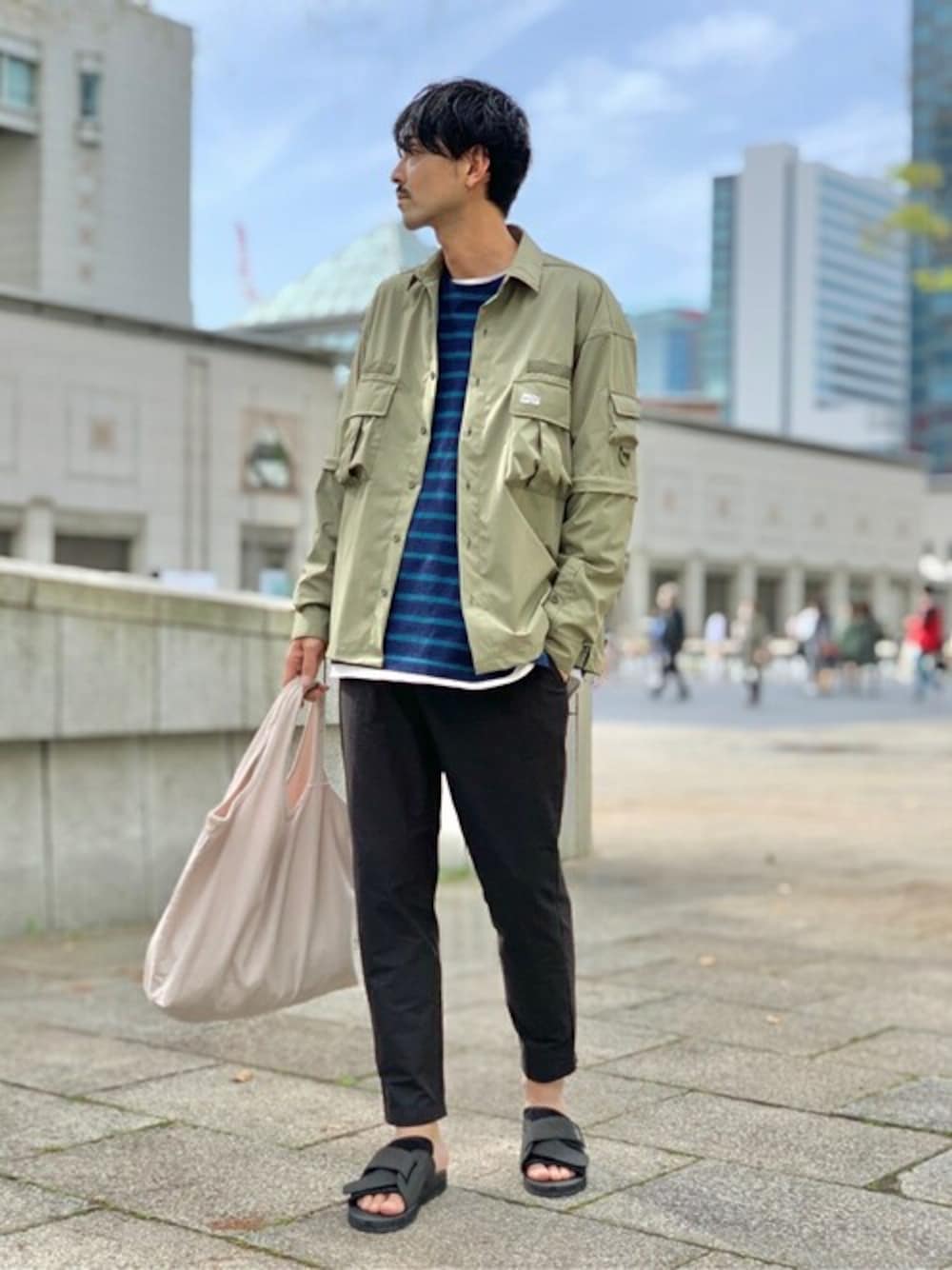 グリーン系のシャツ/ブラウス、ブラック系のスラックス、ブラック系のサンダルを着用したメンズの春コーディネートの1枚目の写真