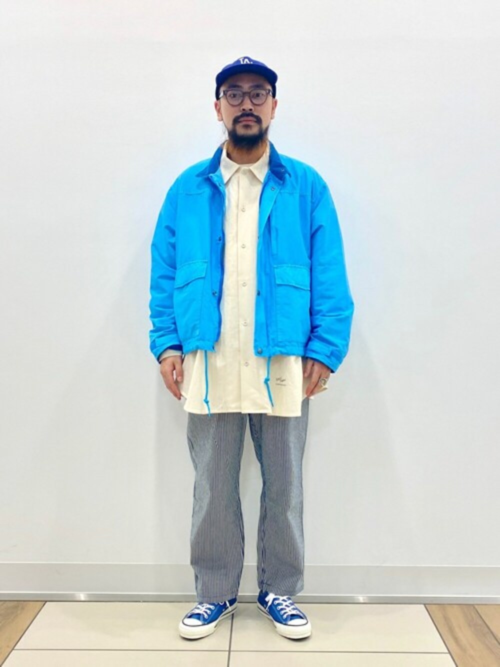 ブルー系のその他パンツ、ブルー系のナイロンジャケット、ホワイト系のシャツ/ブラウスを着用したメンズの春コーディネートの1枚目の写真