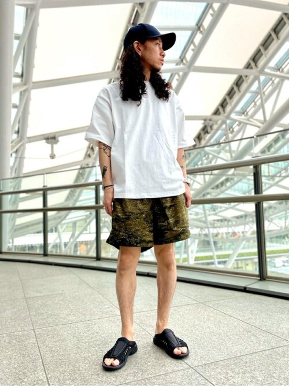 ホワイト系のTシャツ/カットソー、グリーン系のその他パンツ、ブラック系のサンダルを着用したメンズの夏コーディネートの1枚目の写真
