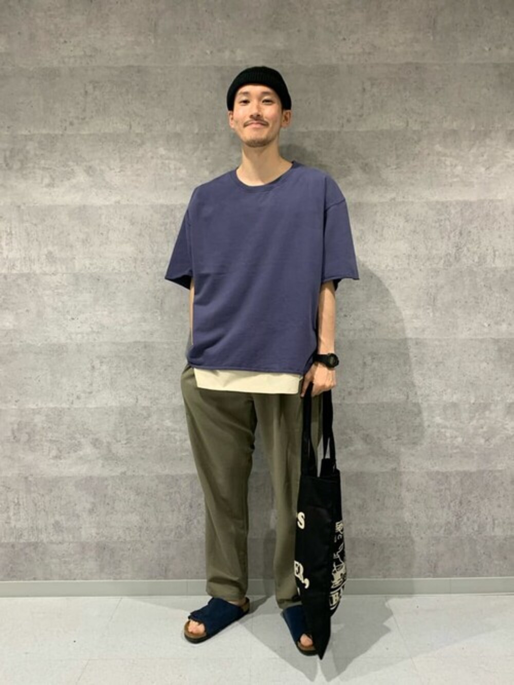 グレー系のTシャツ/カットソー、ホワイト系のタンクトップ、グリーン系のスラックスを着用したメンズの夏コーディネートの1枚目の写真