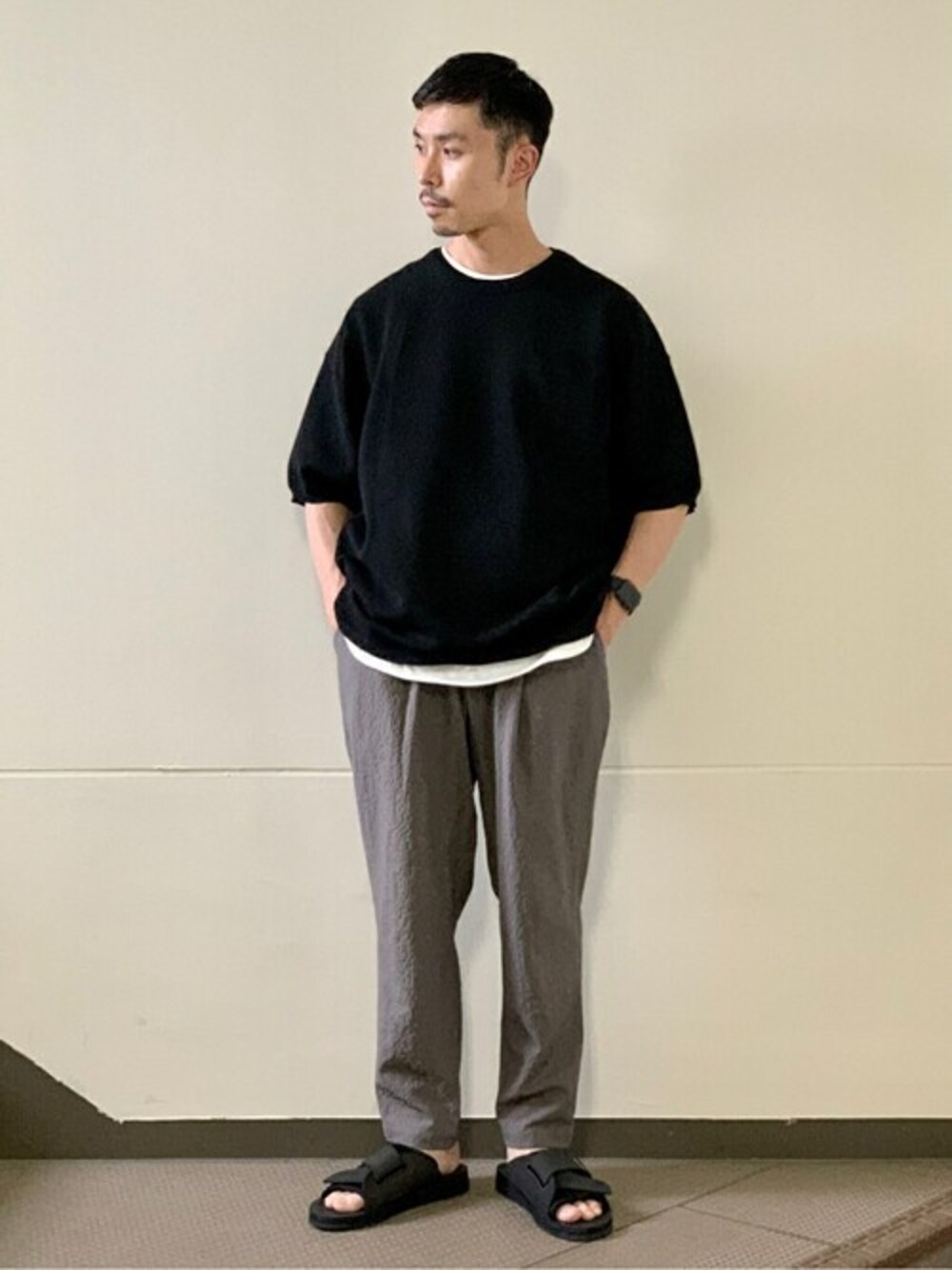 ブラック系のTシャツ/カットソー、ホワイト系のTシャツ/カットソー、ベージュ系のスラックスを着用したメンズの夏コーディネートの1枚目の写真